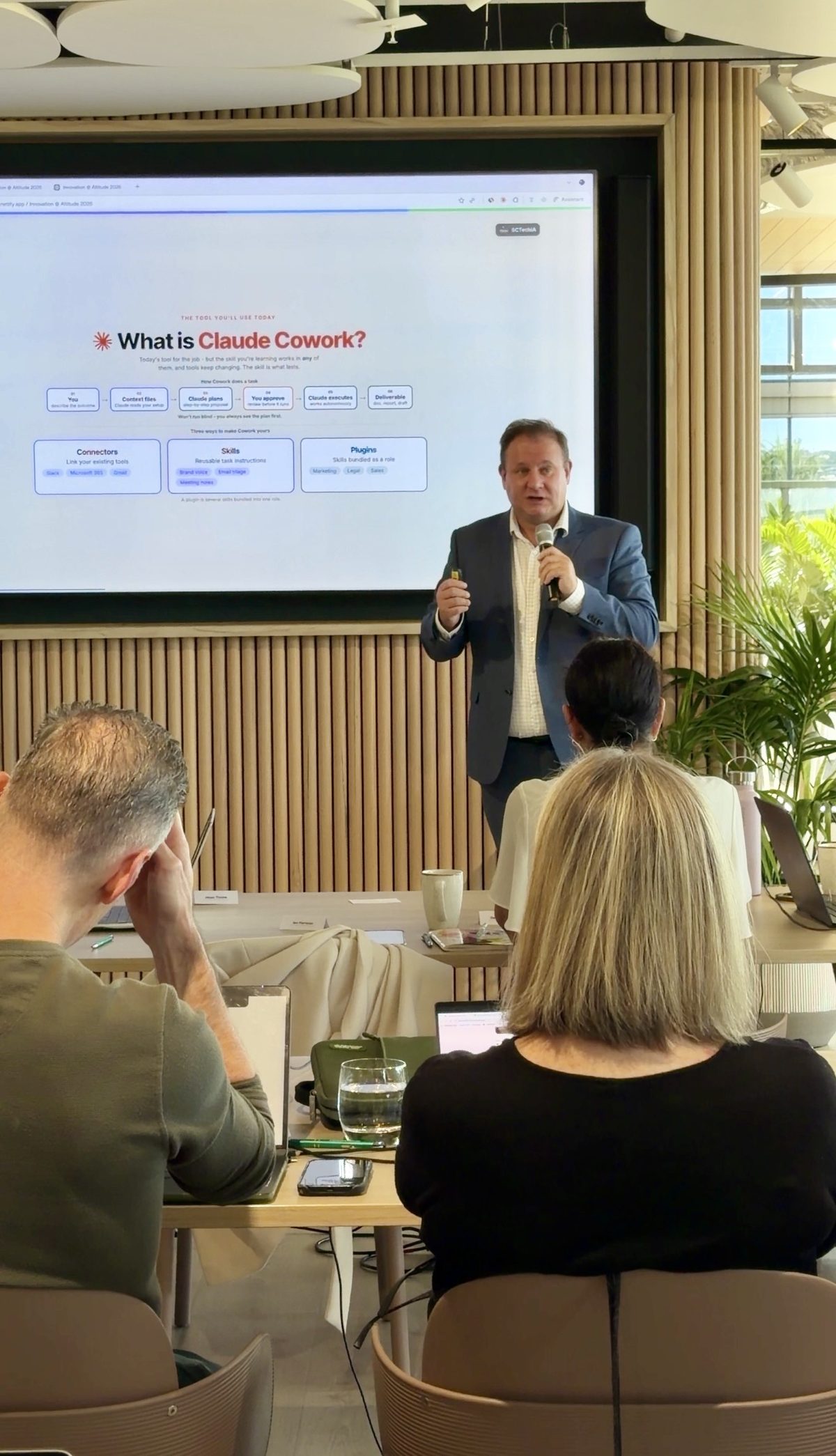 Bart Puszko teaching a hands-on AI workshop, with business leaders following along on laptops