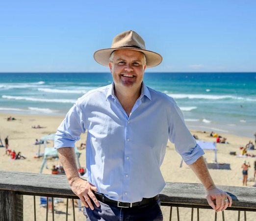 Ted O'Brien MP in a wide-brimmed hat, with the beach behind him
